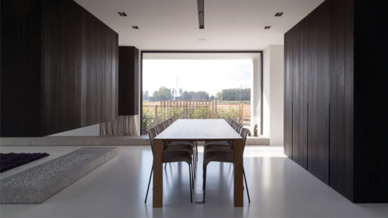 A modern interior design with dark wood ceiling height cabinets and a white floor.