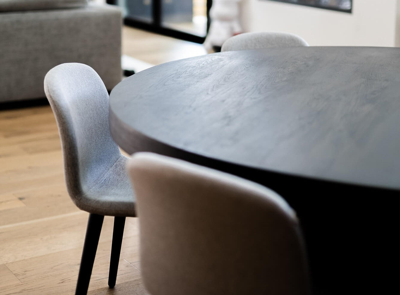 An angled view of a white oak modern round dining table finished with Rubio Monocoat products.