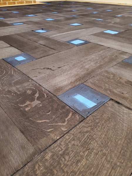 Close up image of a white oak basketweave hardwood floor treated with Rubio Monocoat Fumed Intense.