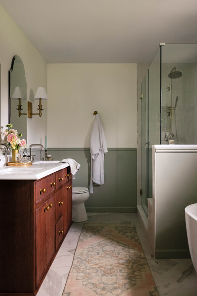 A transitional bathroom featuring a white oak vanity finished with Oil Plus 2C. This renovated bathroom also features a walk in shower, freestanding tub and beautiful marble flooring.