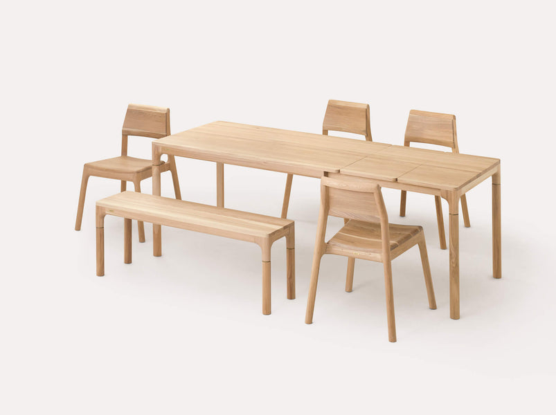 An extendable table dining set made from European oak wood. This set includes a table with two leaves, four chairs, and a bench.