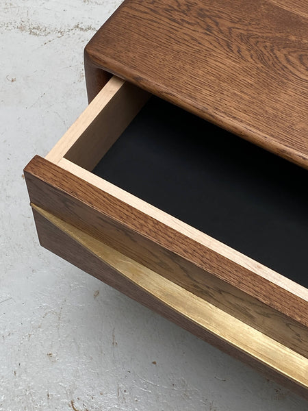 A European oak nightstand finished with Oil Plus 2C "Chocolate" features a hand-shaped brass pull.