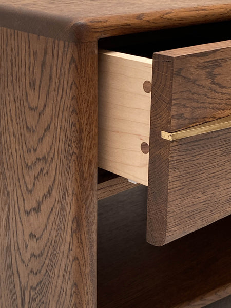 Details on an oak nightstand with brass accents.