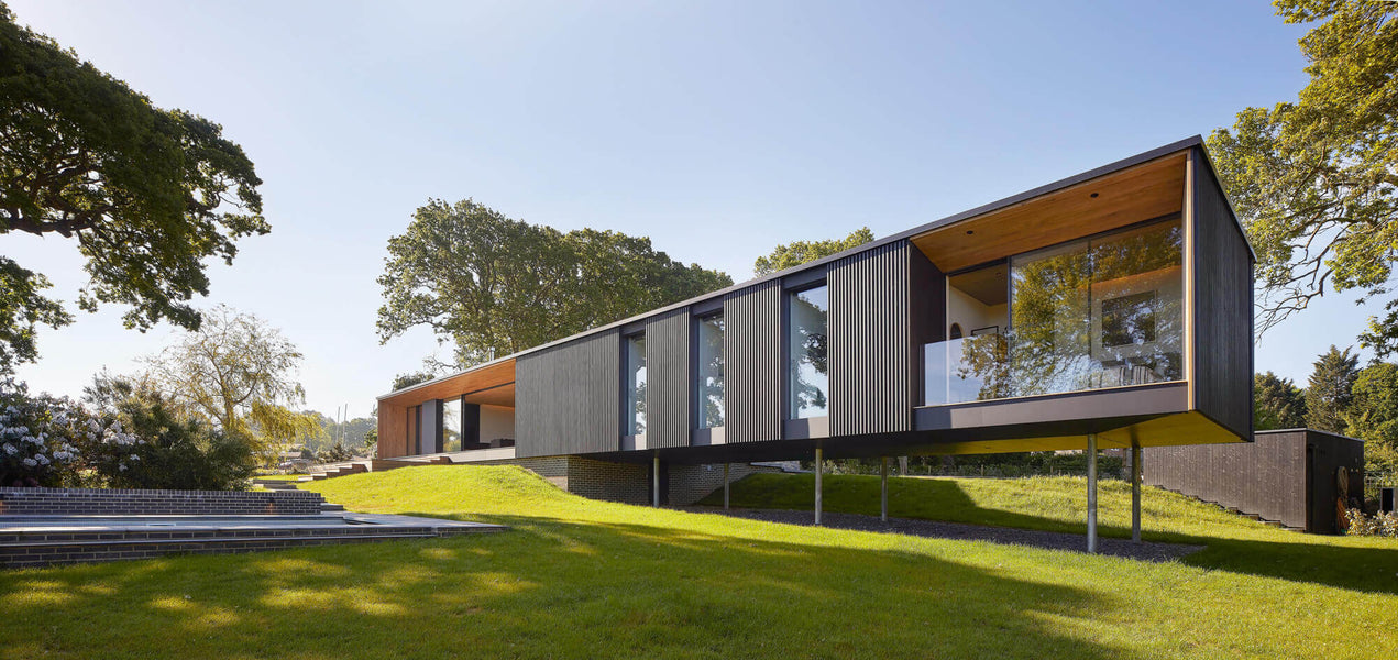 Daytime image of a modern vacation home with wood slatted siding finished with Rubio Monocoat hardwax oil Hybrid Wood Protector.